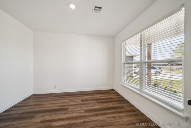 unfurnished room with recessed lighting, dark wood-type flooring, visible vents, and baseboards