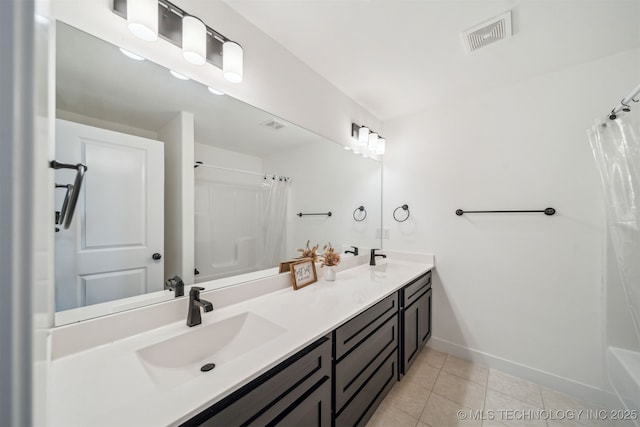 bathroom featuring visible vents, baseboards, a shower with curtain, a sink, and tile patterned floors