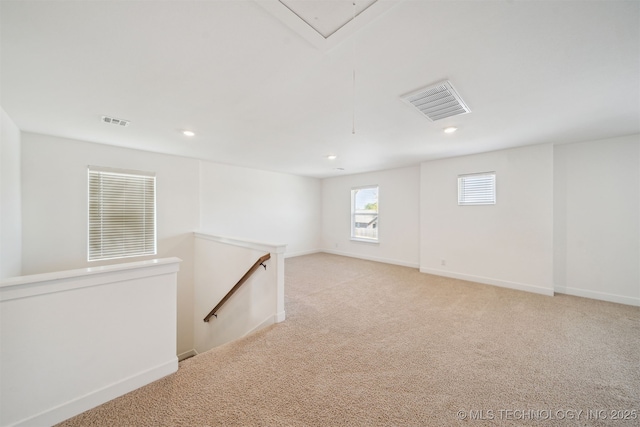 basement featuring visible vents, recessed lighting, and light carpet