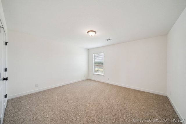 spare room featuring light carpet, visible vents, and baseboards