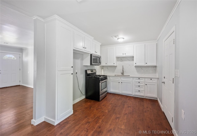 920 E 33rd St N, Tulsa, OK 74106 - kitchen with stainless steel appliances, a sink, white cabinets, dark wood finished floors, and light countertops