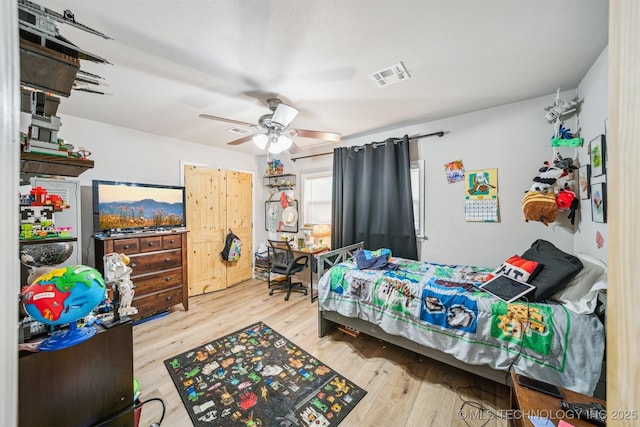 bedroom featuring light wood-type flooring, visible vents, and ceiling fan