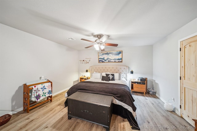 bedroom featuring baseboards, a ceiling fan, wood finished floors, and visible vents