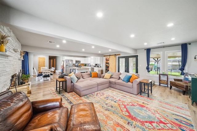 living room featuring recessed lighting, visible vents, and light wood-type flooring