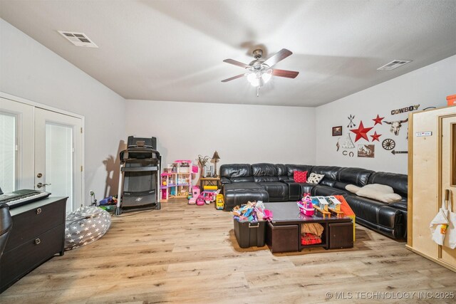 living room featuring wood finished floors, visible vents, and a ceiling fan