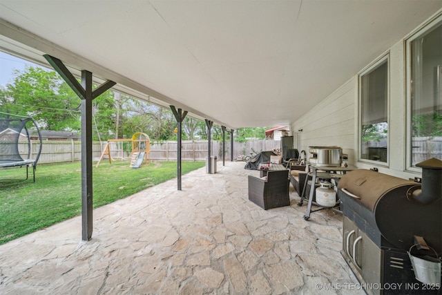 view of patio featuring grilling area, a fenced backyard, a playground, and a trampoline