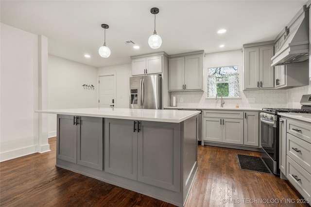 kitchen featuring custom exhaust hood, gray cabinets, backsplash, and appliances with stainless steel finishes