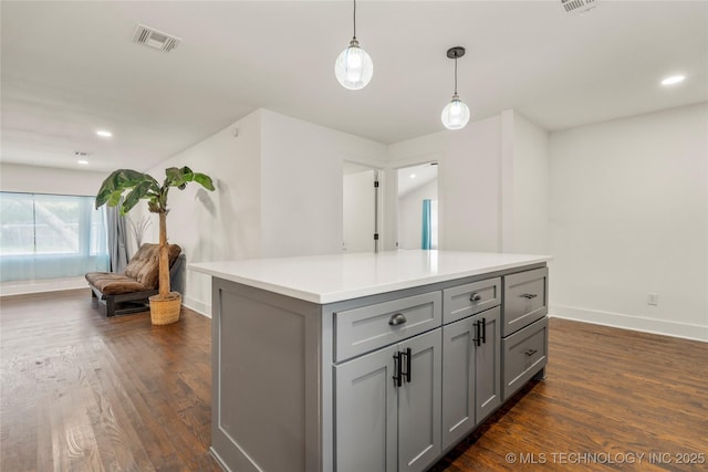 kitchen with dark wood-type flooring, visible vents, baseboards, and gray cabinetry