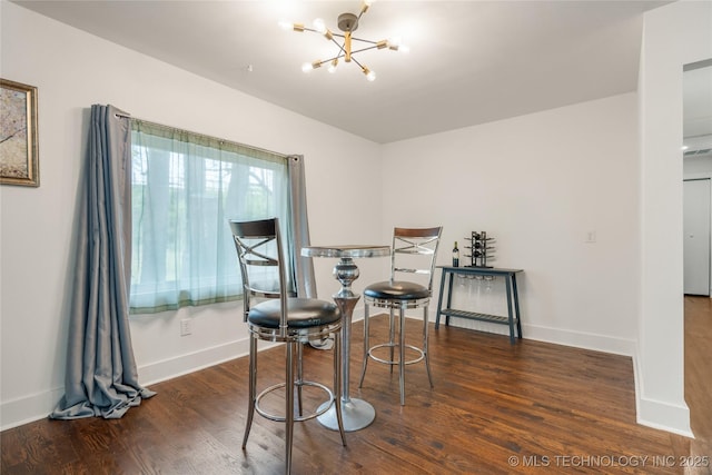 dining space with wood finished floors, a notable chandelier, and baseboards