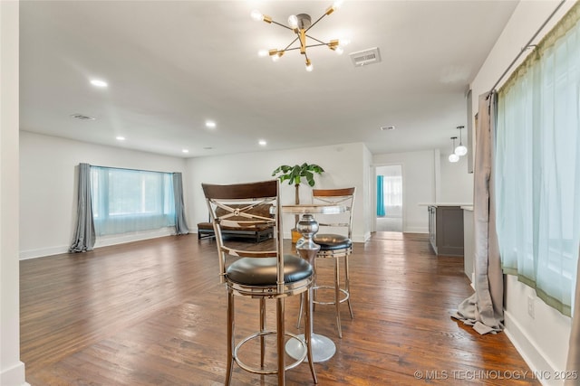 dining room with baseboards, a notable chandelier, dark wood finished floors, and visible vents