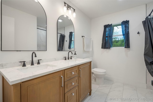bathroom with double vanity, marble finish floor, a sink, and toilet