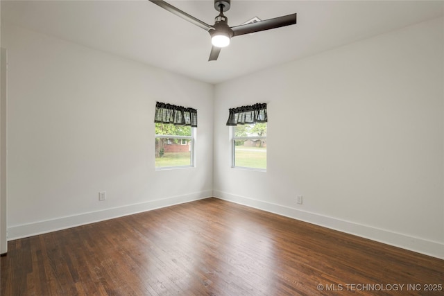 spare room featuring dark wood-type flooring, baseboards, and ceiling fan
