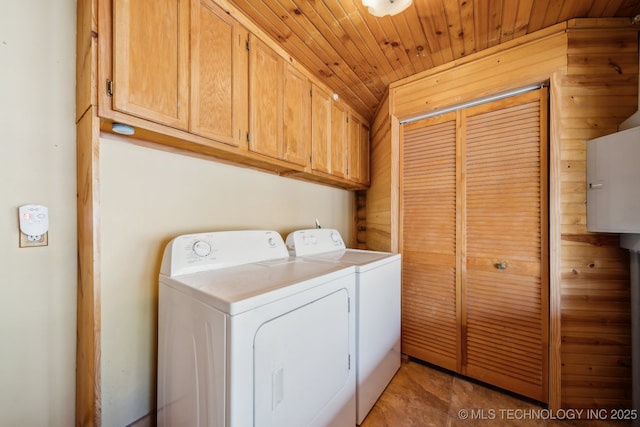 clothes washing area with wooden ceiling, separate washer and dryer, and cabinet space