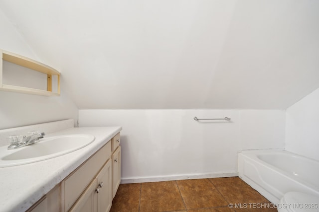 full bathroom with toilet, lofted ceiling, tile patterned flooring, vanity, and a tub