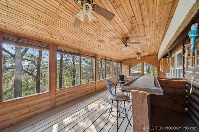 sunroom / solarium with ceiling fan and an outdoor bar