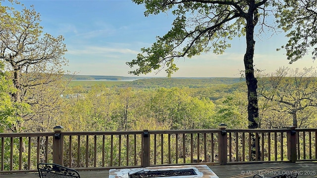 view of yard featuring a view of trees and a deck