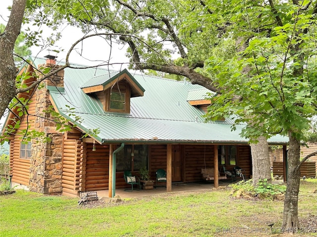 14484 Valley View Dr, Skiatook, OK 74070 - rear view of property featuring log siding, a chimney, a metal roof, and a yard