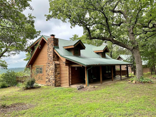 14484 Valley View Dr, Skiatook, OK 74070 - view of side of home with a chimney, a yard, a metal roof, and log exterior
