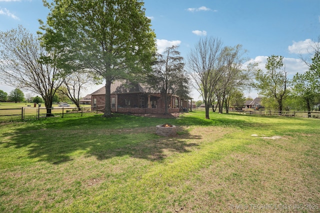 view of yard featuring a fire pit and fence