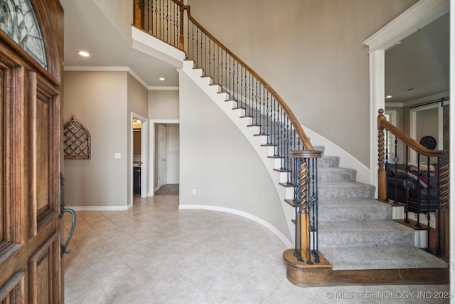 entryway featuring a towering ceiling, baseboards, recessed lighting, stairway, and light tile patterned flooring