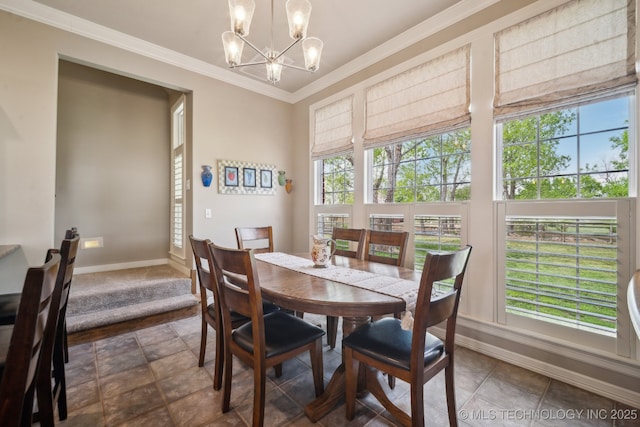 dining area featuring crown molding, a healthy amount of sunlight, a notable chandelier, and baseboards