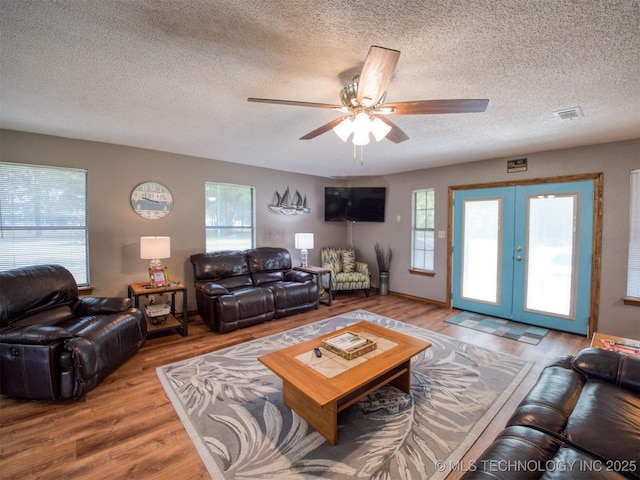 1668 Waters Rd, Kingston, OK 73439 - living area with french doors, a textured ceiling, visible vents, ceiling fan, and wood finished floors