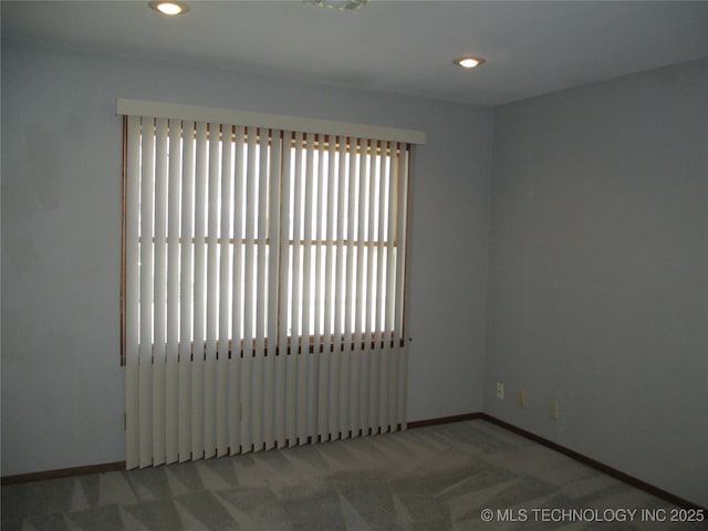 empty room with carpet flooring, baseboards, and recessed lighting