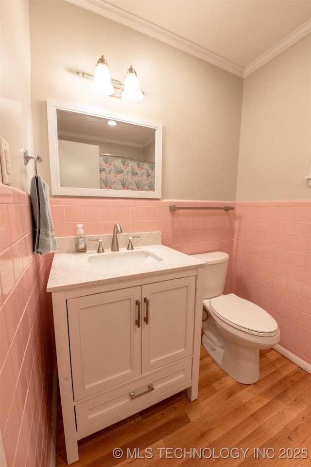 1425 S Madison Blvd, Bartlesville, OK 74006 - bathroom with vanity, a wainscoted wall, toilet, wood finished floors, and tile walls