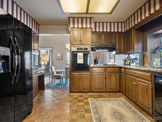 8404 S Toledo Ave, Tulsa, OK 74137 - kitchen with brown cabinetry, black appliances, under cabinet range hood, light stone counters, and a sink
