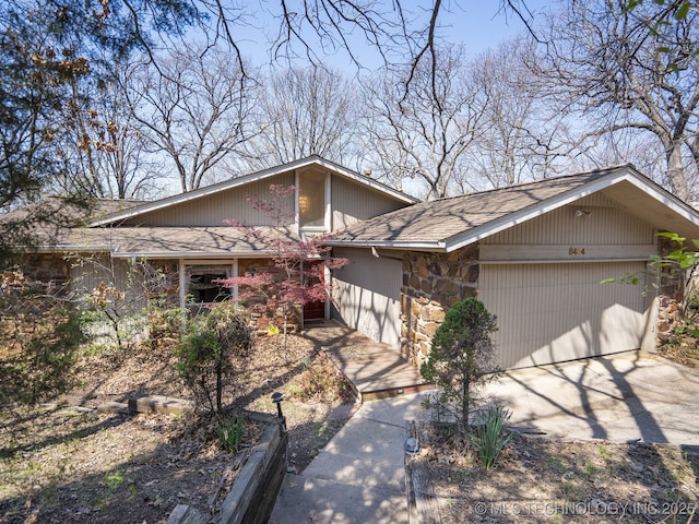 8404 S Toledo Ave, Tulsa, OK 74137 - view of front facade with a garage, stone siding, and concrete driveway