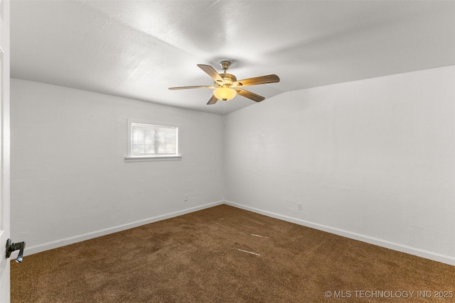 unfurnished room with baseboards, a ceiling fan, dark colored carpet, and vaulted ceiling