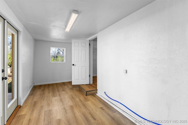 unfurnished room featuring light wood-style flooring and baseboards