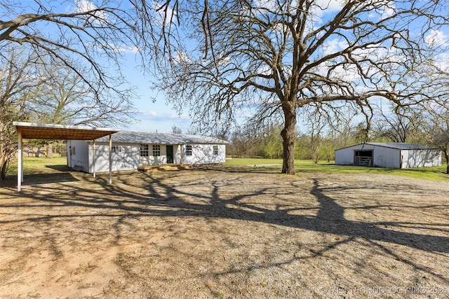 view of yard featuring a carport and an outbuilding