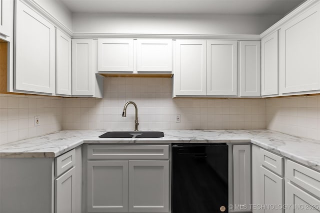 kitchen with decorative backsplash, a sink, white cabinetry, and light stone countertops