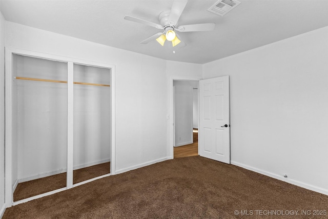 unfurnished bedroom with a closet, baseboards, visible vents, ceiling fan, and carpet