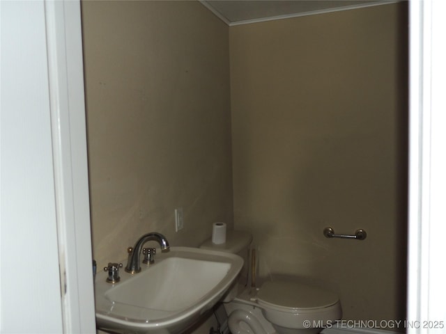 906 S 85th E Ave, Tulsa, OK 74112 - bathroom featuring crown molding, a sink, and toilet