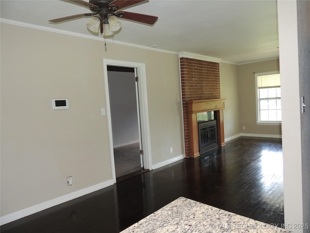 906 S 85th E Ave, Tulsa, OK 74112 - unfurnished living room featuring ceiling fan, crown molding, a brick fireplace, wood finished floors, and baseboards
