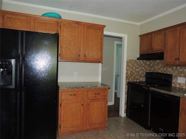 906 S 85th E Ave, Tulsa, OK 74112 - kitchen with dark stone counters, light tile patterned floors, tasteful backsplash, under cabinet range hood, and black appliances