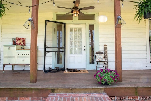view of exterior entry with a porch and ceiling fan