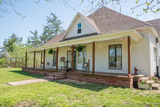 farmhouse inspired home with a front yard, a porch, and roof with shingles