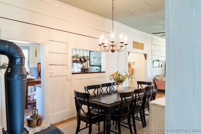 dining room with a chandelier, wood finished floors, and ornamental molding