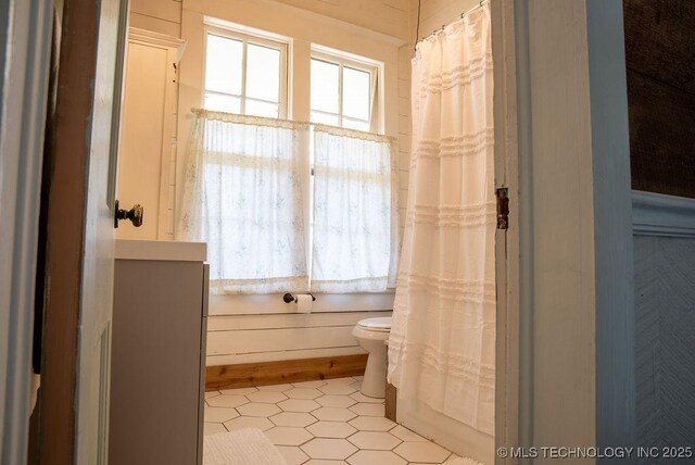 full bathroom with tile patterned floors, curtained shower, and toilet