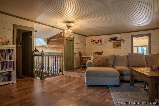 living room featuring wooden walls, lofted ceiling, a ceiling fan, and wood finished floors