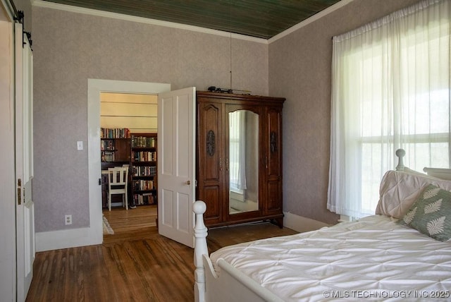bedroom with crown molding, baseboards, and wood finished floors
