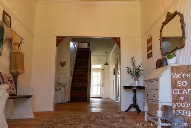 entryway with stairway, a high ceiling, and wood finished floors