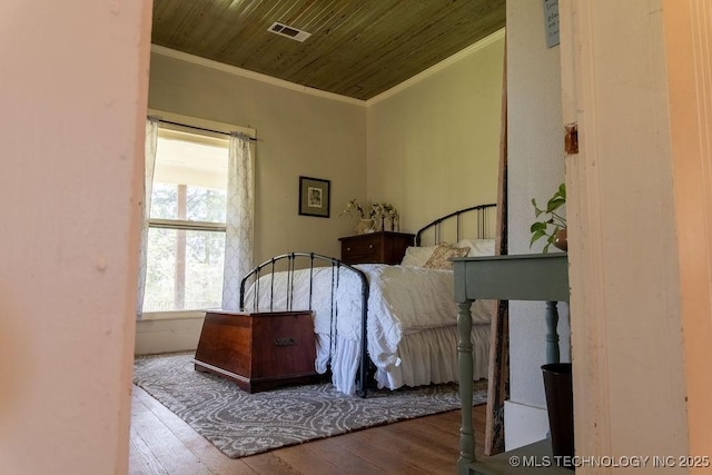 bedroom featuring wood ceiling, wood-type flooring, ornamental molding, and visible vents