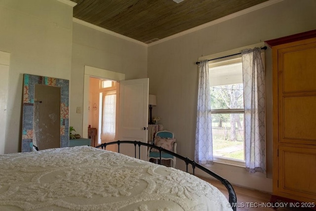 bedroom featuring wooden ceiling, ornamental molding, and wood finished floors