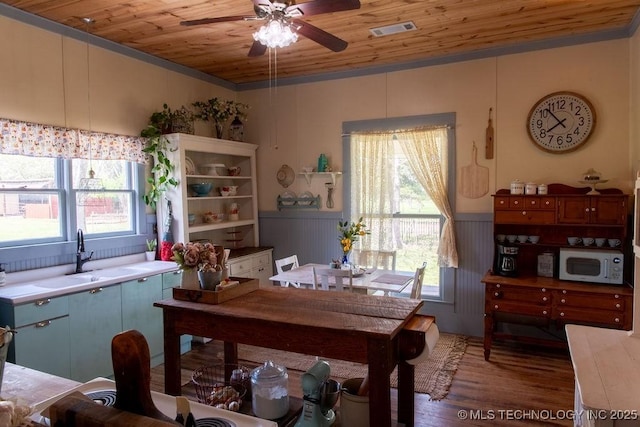office with a ceiling fan, visible vents, wooden ceiling, a sink, and wainscoting