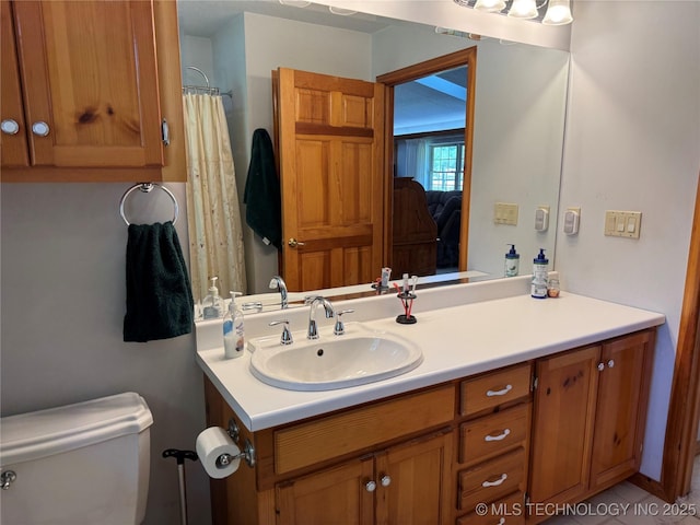 bathroom featuring toilet, curtained shower, and vanity
