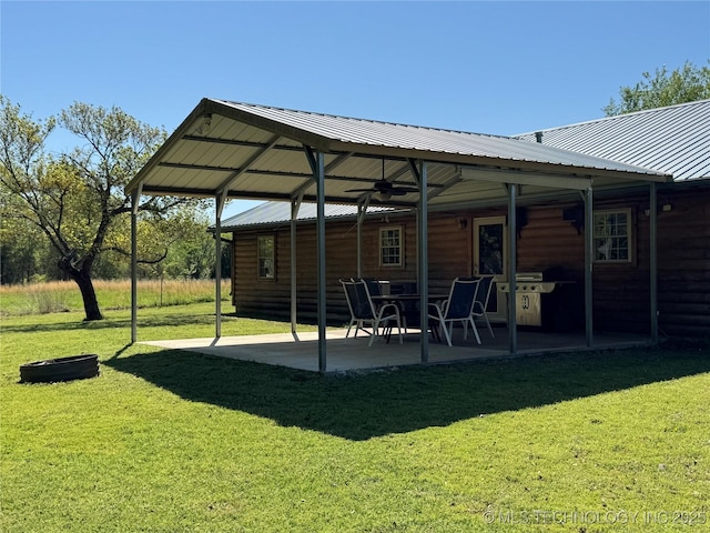 back of house with a patio, a yard, metal roof, and faux log siding